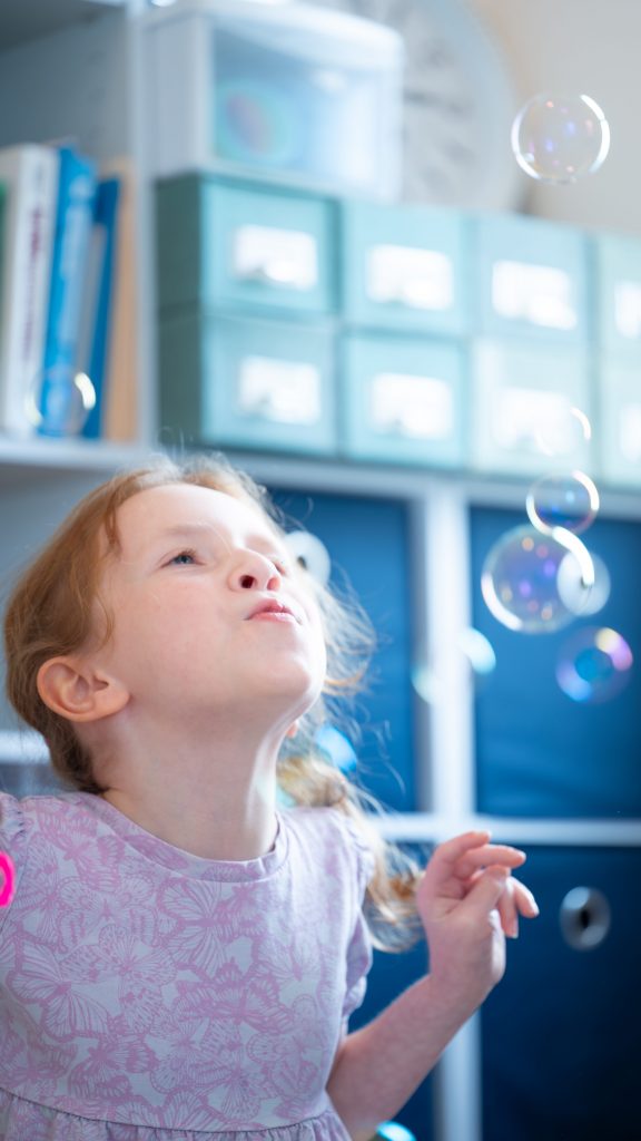 child blowing bubbles